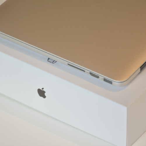 Apple laptop on its retail box during intake or return preparation.