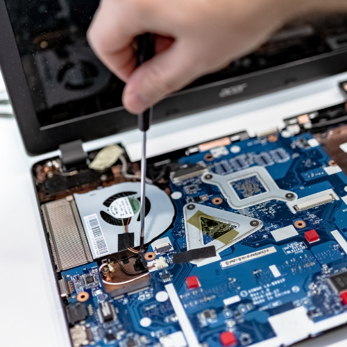Technician adjusting a motherboard with a precision screwdriver.